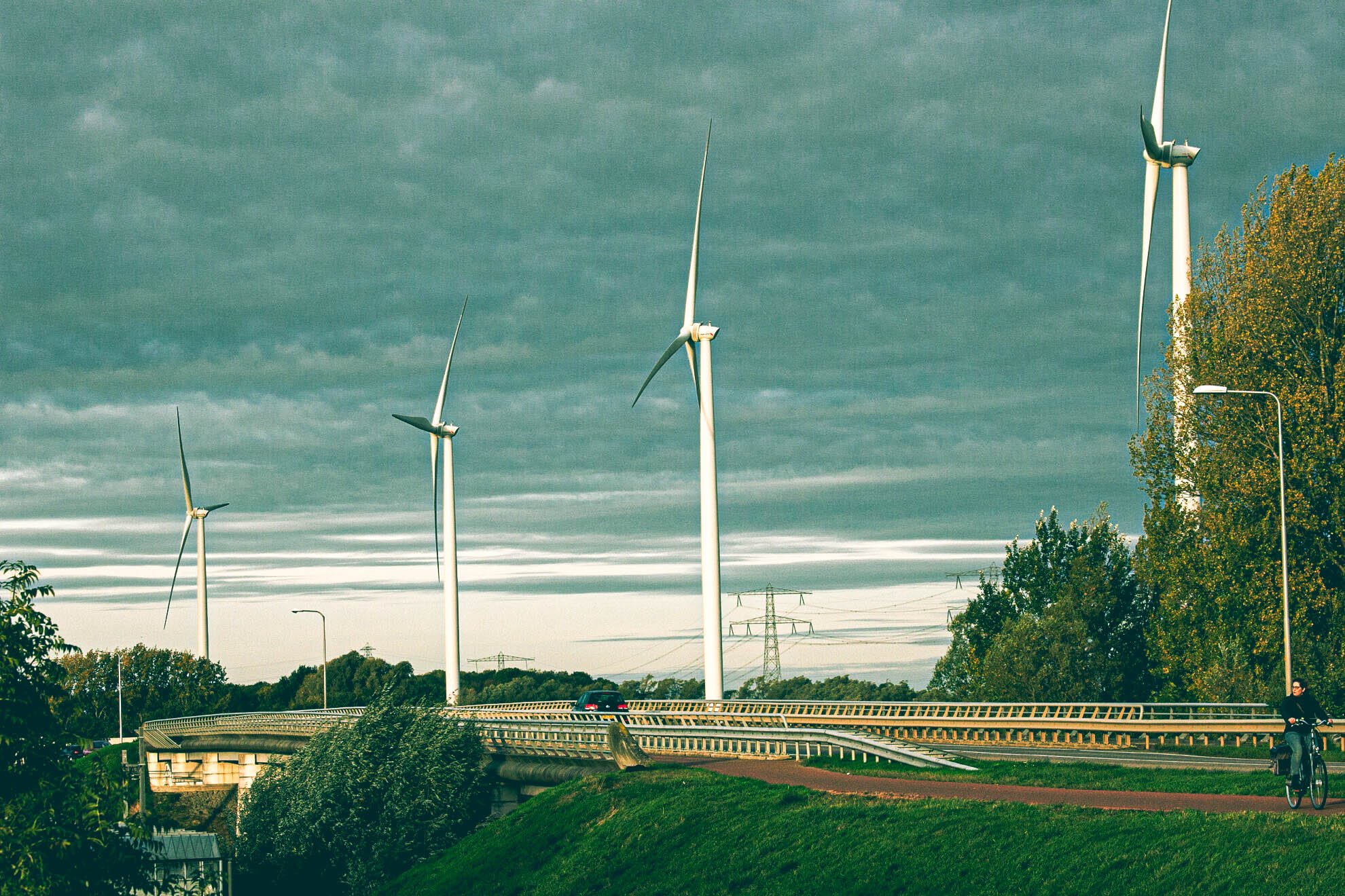 windmolens vlakbij een openbare weg. Dit soort opwekinstallaties zijn te koppelen door middel van cable pooling.