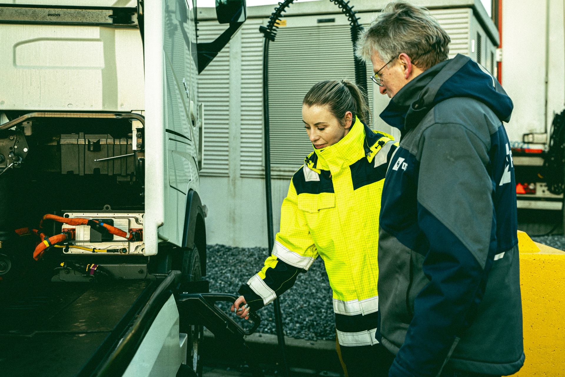 Vrouw en man staan naast elektrische vrachtwagen