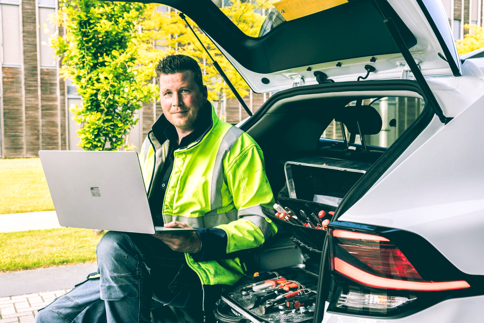 Elektriciteit op de bouwplaats. Medewerker met laptop.